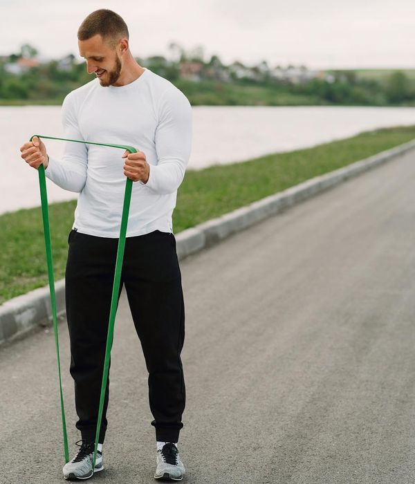 Smiling person stretching outdoors, feeling full of energy.